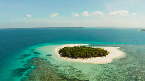 Sandy beach and tropical island by atoll. patawan island with sandy beach. 