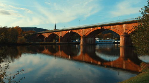 Arch bridge over river against sky