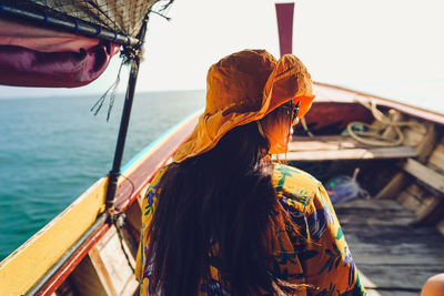 Rear view of woman on boat in sea against sky