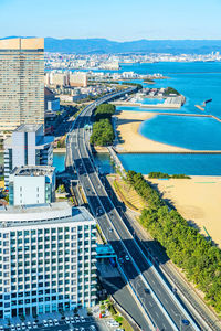 High angle view of city by sea against sky