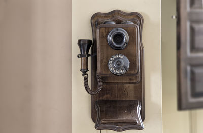 Close-up of rotary phone on wall