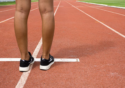 Low section of woman standing on zebra crossing