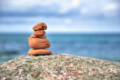 Close-up of sculpture on rock by sea against sky