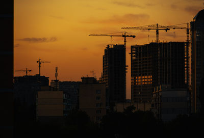 Silhouette buildings against sky during sunset