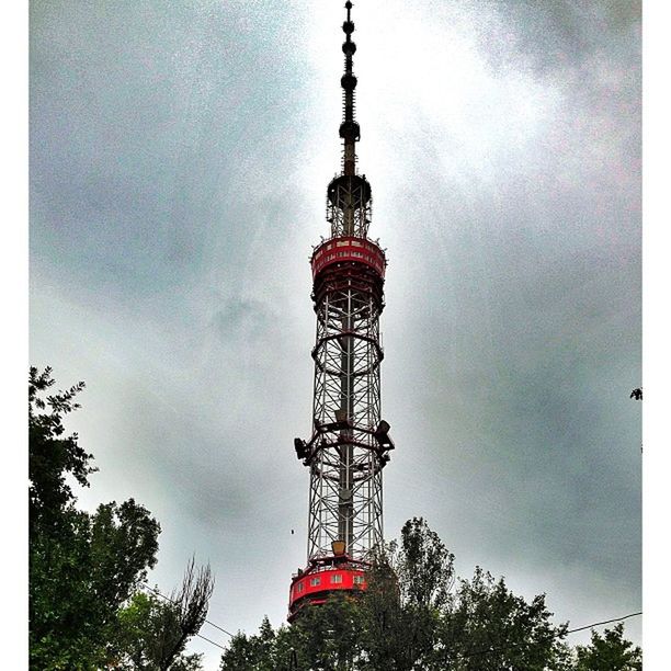 low angle view, sky, tower, communications tower, tall - high, built structure, cloud - sky, communication, architecture, tree, cloudy, building exterior, cloud, television tower, fernsehturm, day, tall, outdoors, travel destinations, blue