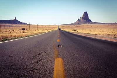 Road amidst field against sky