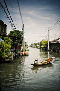 Man in boat on river in city