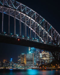 Illuminated bridge over river at night