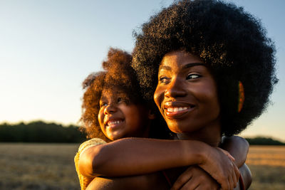 Portrait of smiling young woman against sky