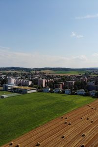 Houses on field against sky in city