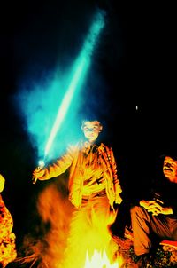 Low angle view of illuminated fire against sky at night