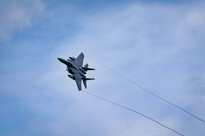 Low angle view of airplane flying against sky