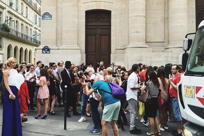 Group of people walking on road against buildings