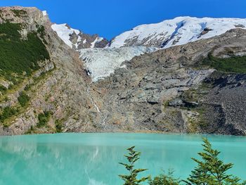 Scenic view of lake and mountains against blue sky