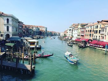 Boats in canal amidst buildings in city