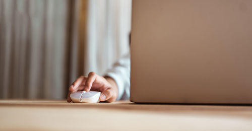 Cropped hand of person holding computer mouse
