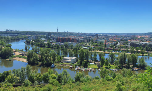 River by cityscape against clear blue sky