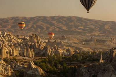 Aerial view of hot air balloons flying over landscape