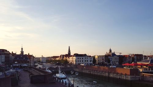 View of cityscape at harbor during sunset