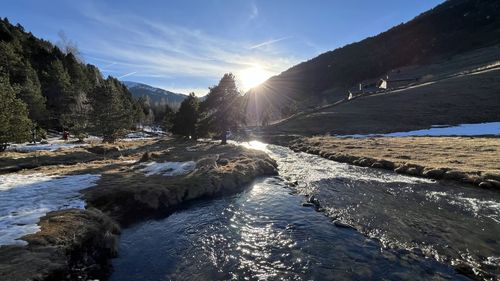 Scenic view of river amidst mountains against sky