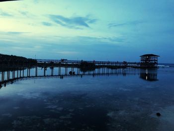 Pier over sea against sky at dusk