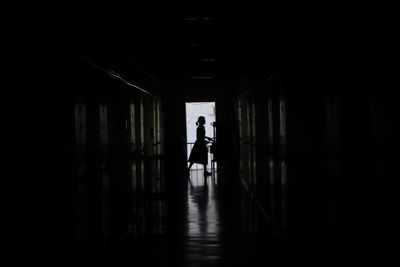 Silhouette people walking in corridor of building