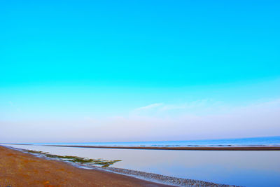 Scenic view of sea against blue sky