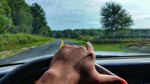 Low section of man with car on road