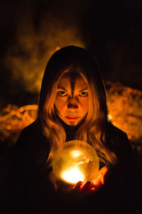 Portrait of woman holding illuminated light