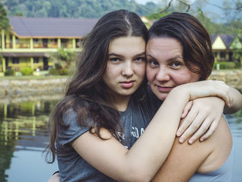 Portrait of daughter embracing mother while standing outdoors