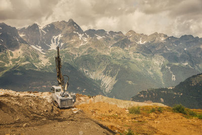 Horse cart on road by mountains against sky