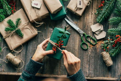 Top view woman's hands wrap craft gifts for christmas.