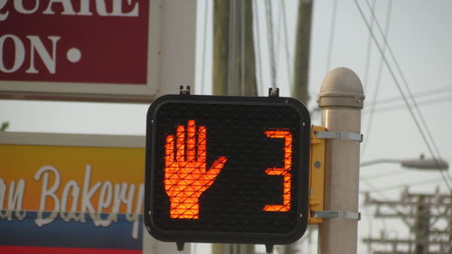 Low angle view of road sign against city