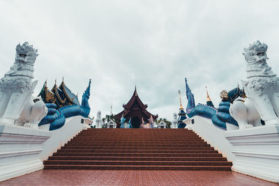 Low angle view of statues on building against sky