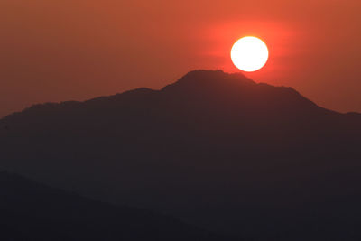 Scenic view of silhouette mountains against clear sky during sunset