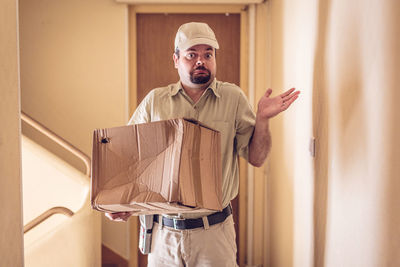 Portrait of young man standing against curtain