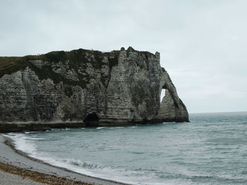 Rock formations by sea against sky