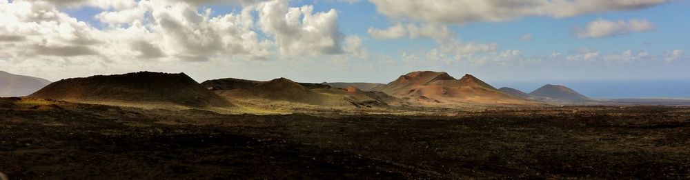 Panoramic view of desert against cloudy sky