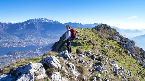 Man standing on rock against sky