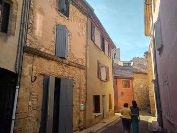 People on street amidst buildings in city