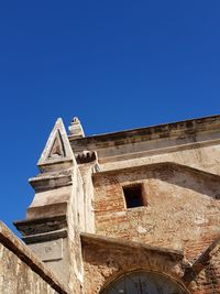 Low angle view of historical building against clear blue sky