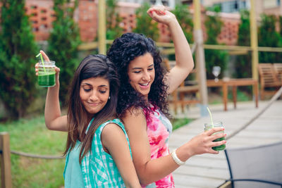 Friends dancing while having drink at restaurant