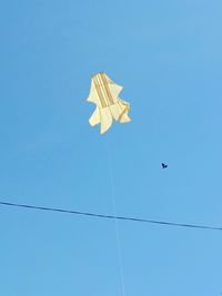 Low angle view of birds flying against blue sky