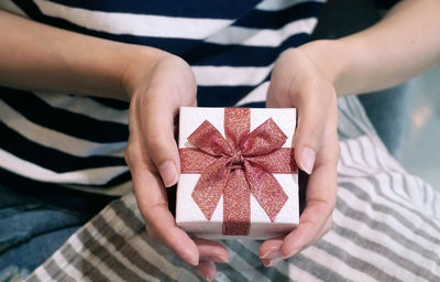 Midsection of woman holding ring in box