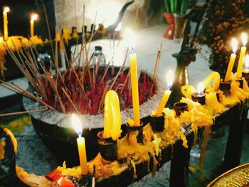 Illuminated candles on temple outside building