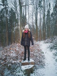 Portrait of girl standing in forest during winter