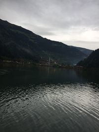 Scenic view of lake by mountains against sky