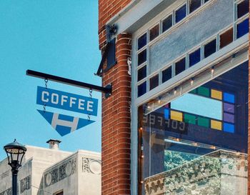 Low angle view of road sign against blue sky