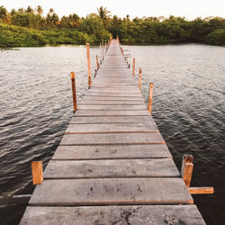 Wooden pier over lake against sky