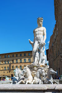 Statue of historic building against blue sky